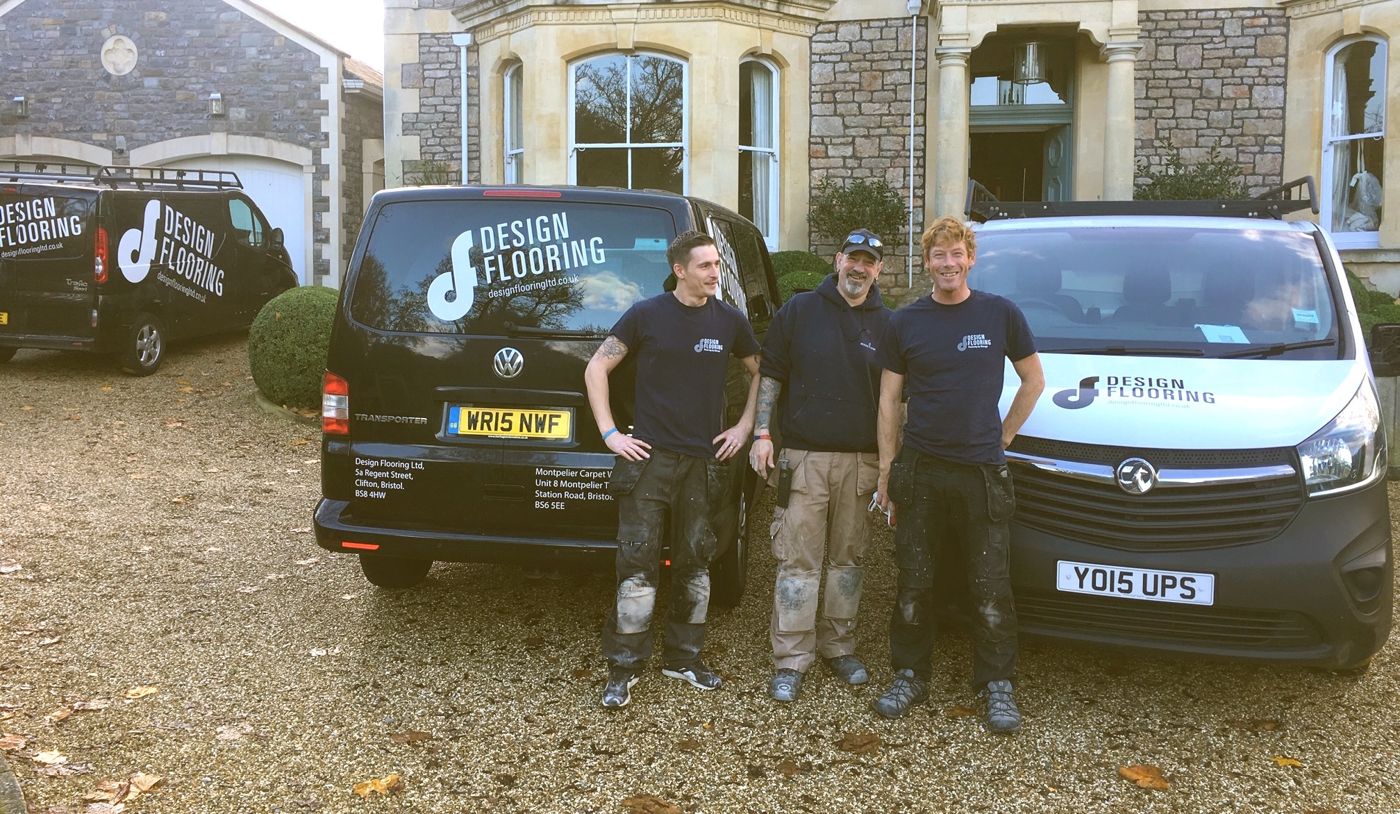 Three Design Flooring fitters in work gear beside the company vans